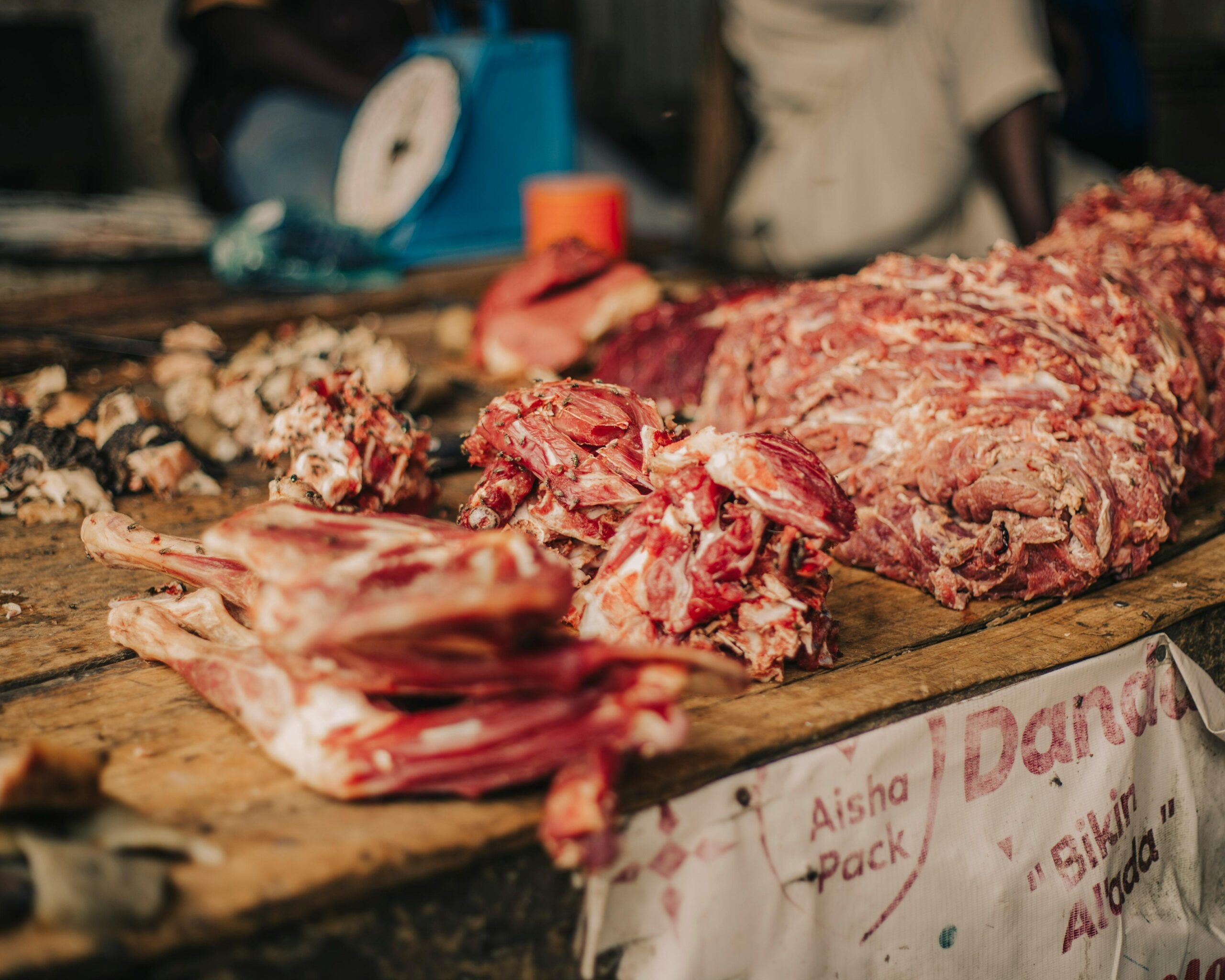 Close-up of fresh meat cuts displayed on a wooden market table, perfect for culinary visuals.