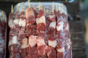 High-quality fresh meat skewers wrapped in plastic, ready for grilling.