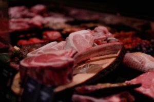 Close-up of a variety of raw meats on display in a market setting, perfect for culinary and food industry themes.